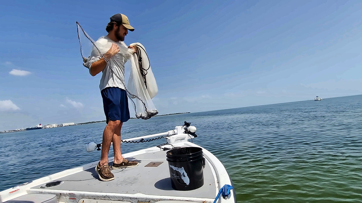 Loading a Dropout cast net on the bow of a boat on Tampa Bay